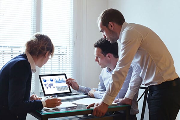 Public health workers looking at reports on a laptop screen